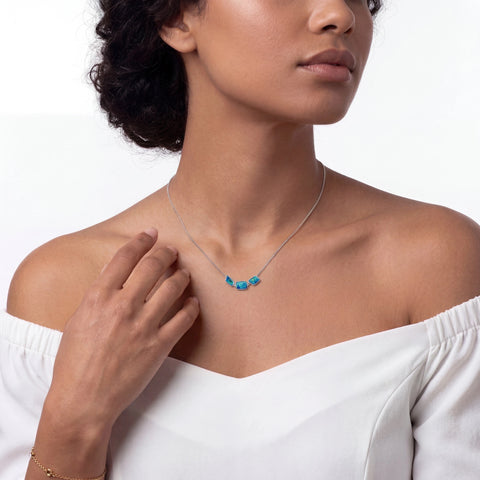 Woman wearing a necklace with turquoise stones on a white background