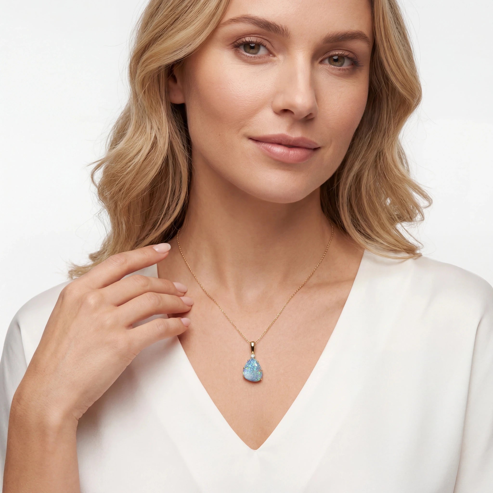 Woman wearing a necklace with a blue opal pendant on a white background