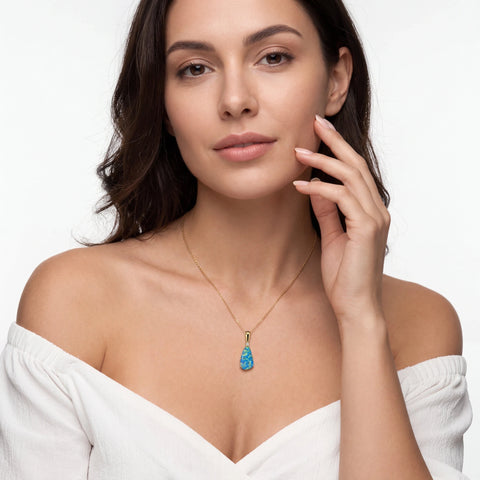 Woman wearing a necklace with a blue opal pendant on a white background