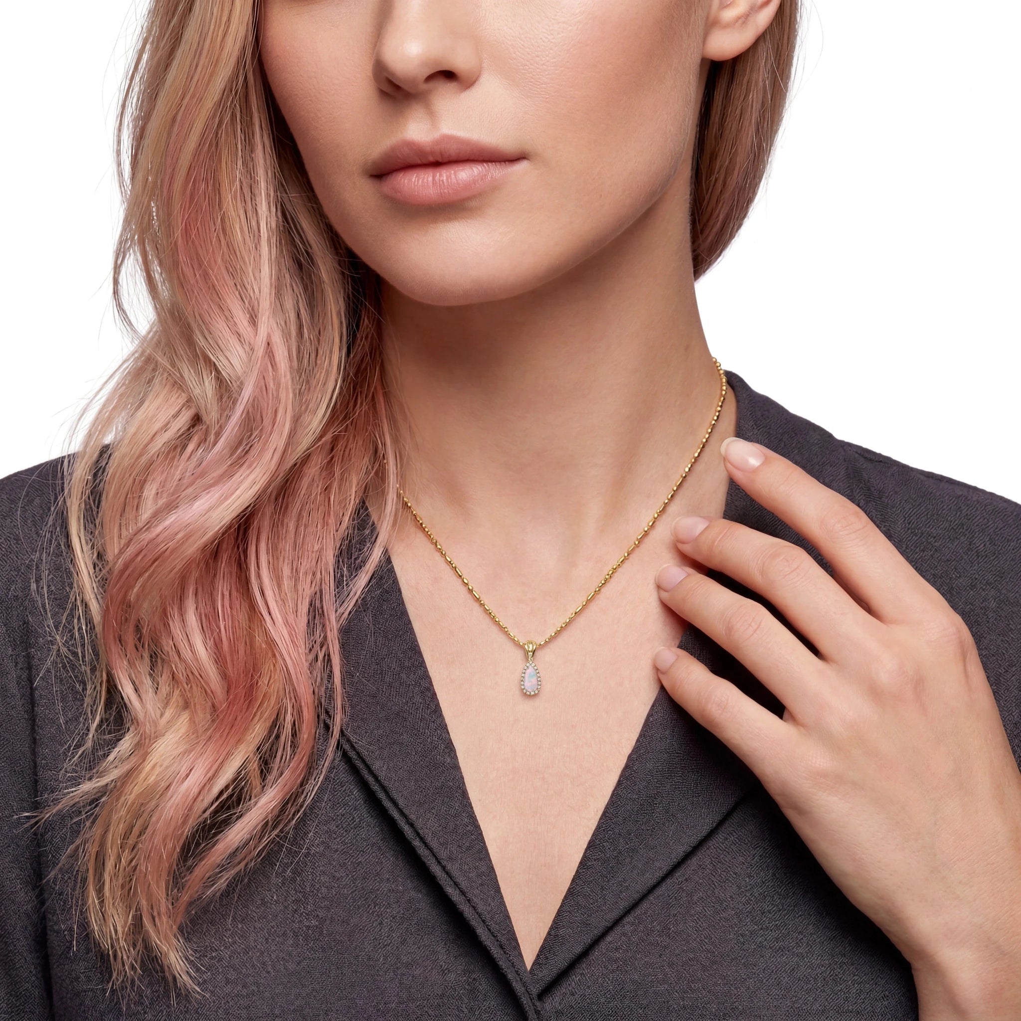 Woman wearing a gold necklace with an opal pendant