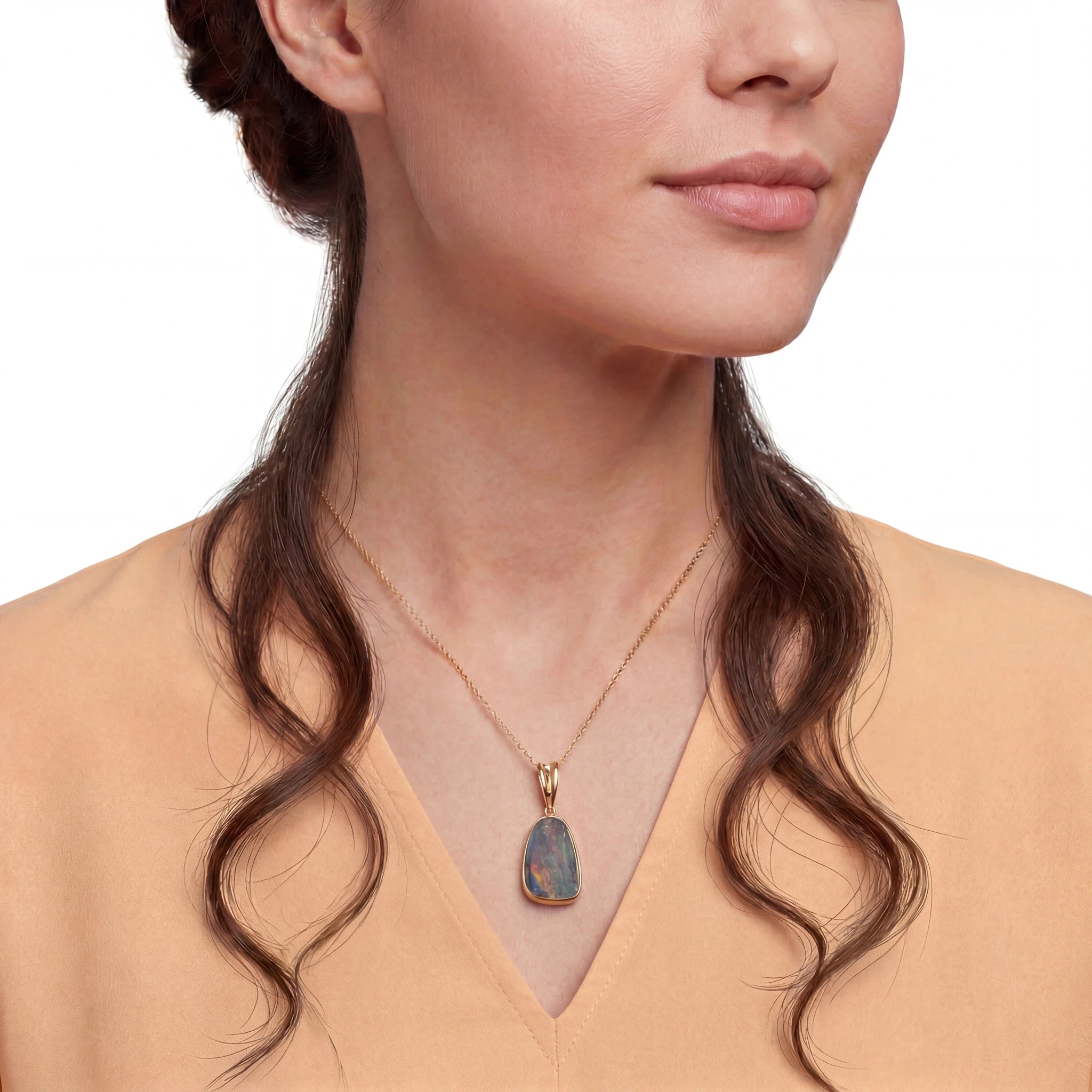 Necklace with an opal pendant worn by a woman on a white background