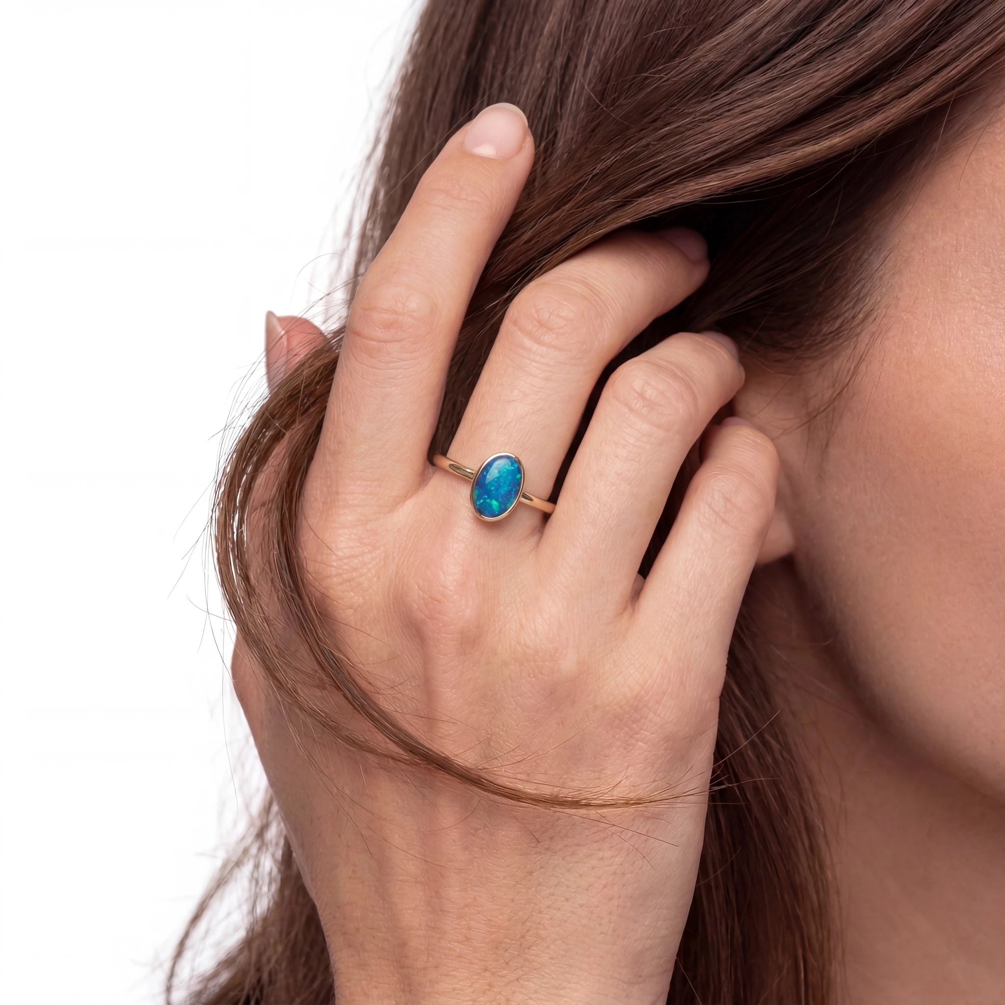 Close-up of a hand wearing a turquoise ring with a blurred background