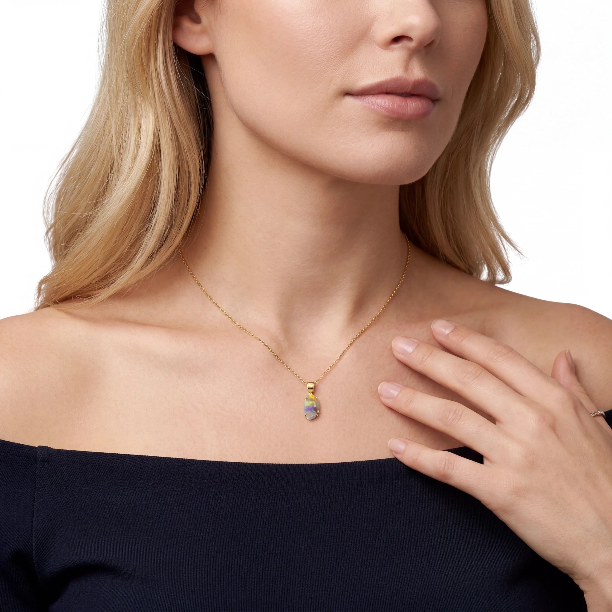 Woman wearing a gold necklace with an opal pendant on a white background
