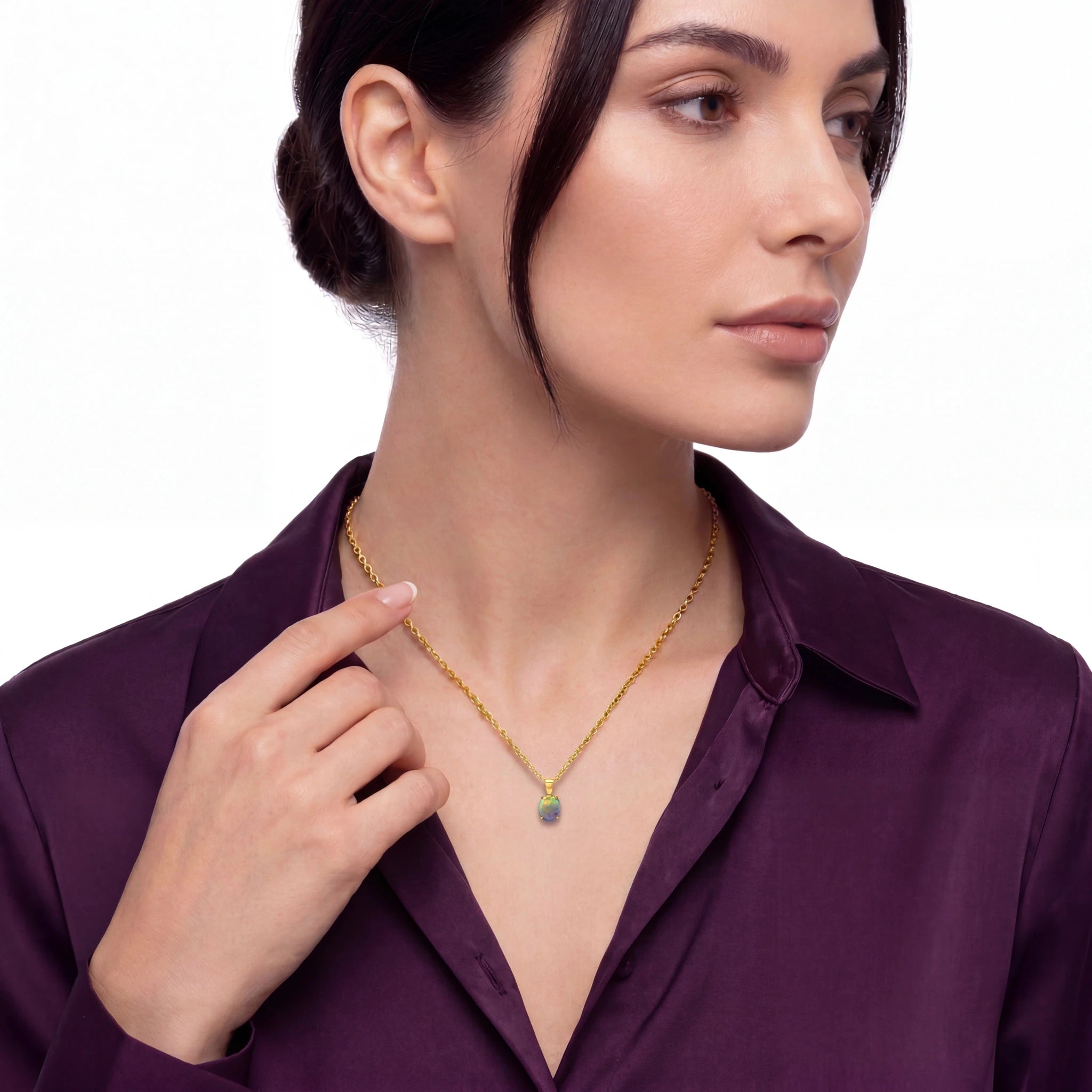 Woman wearing a gold necklace with a purple shirt on a white background