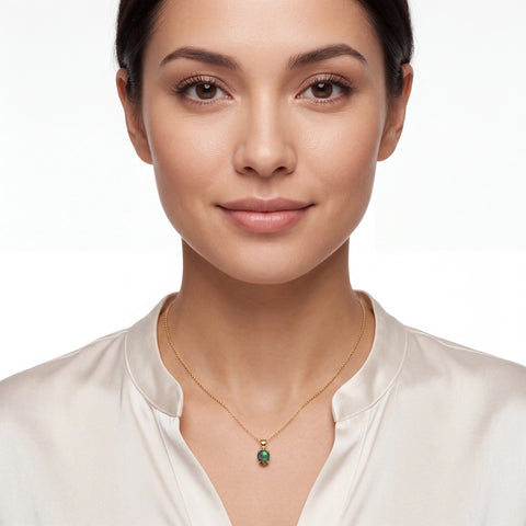 Woman wearing a gold necklace with a green opal pendant on a white background