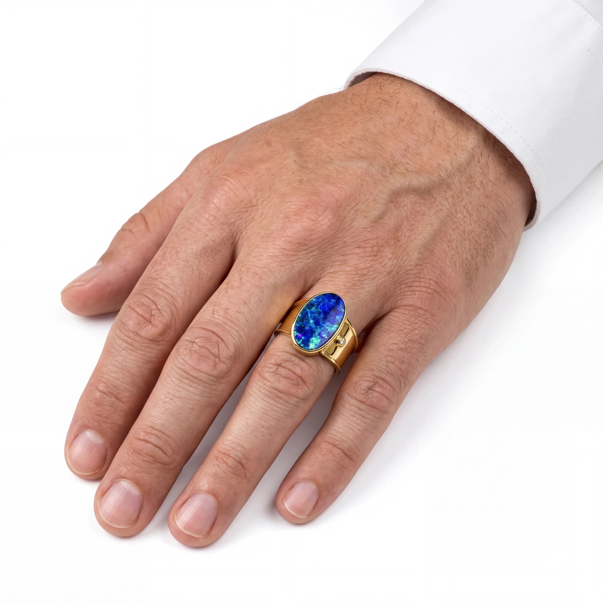 Man wearing a gold ring with a blue gemstone on a white background