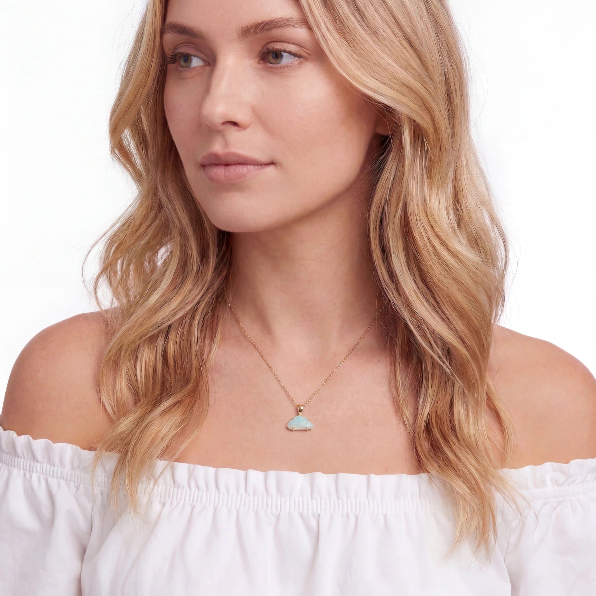 Woman wearing a necklace with a heart-shaped pendant on a white background
