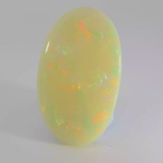 Video of an Opal stone with a yellow and green colour on a white background