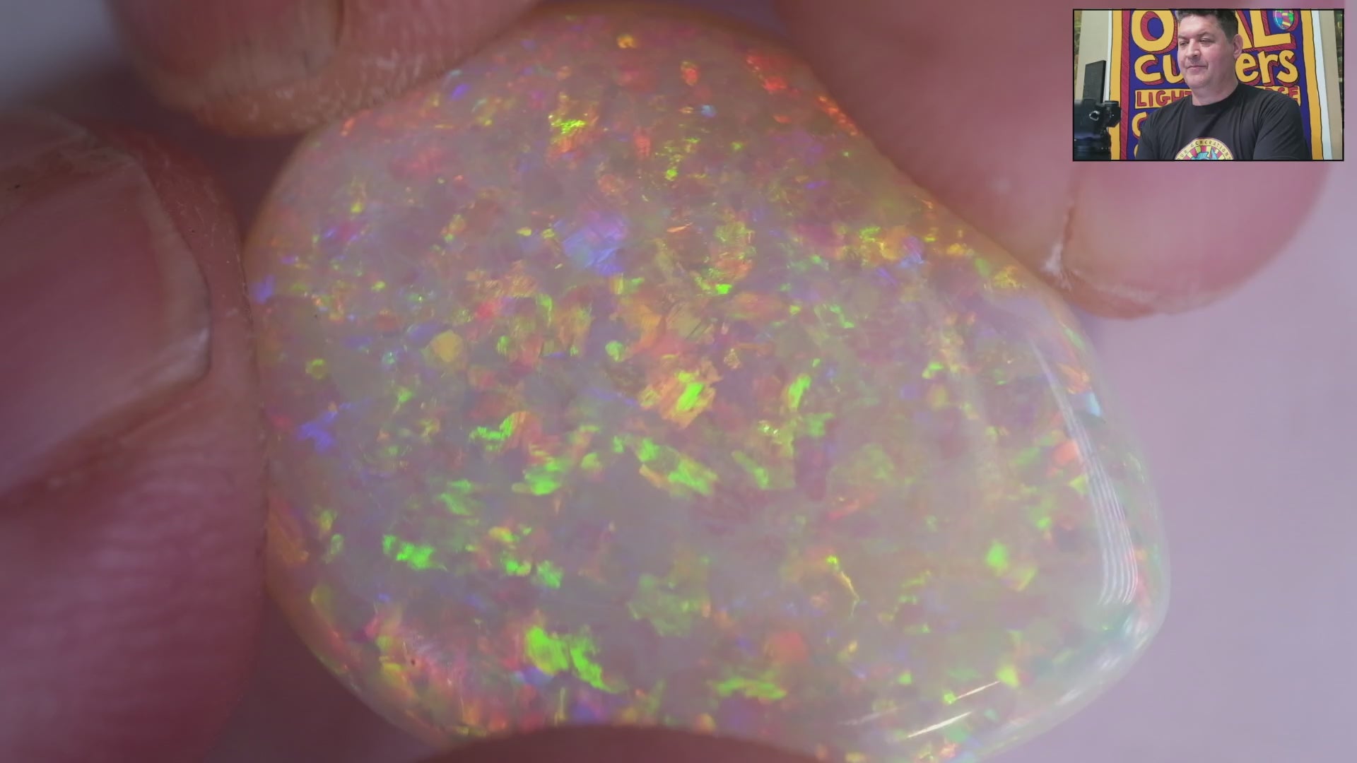 Video of an Opal stone with multicolour play of light on a white background