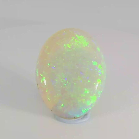 Video of an Opal stone with green and white colours on a white background