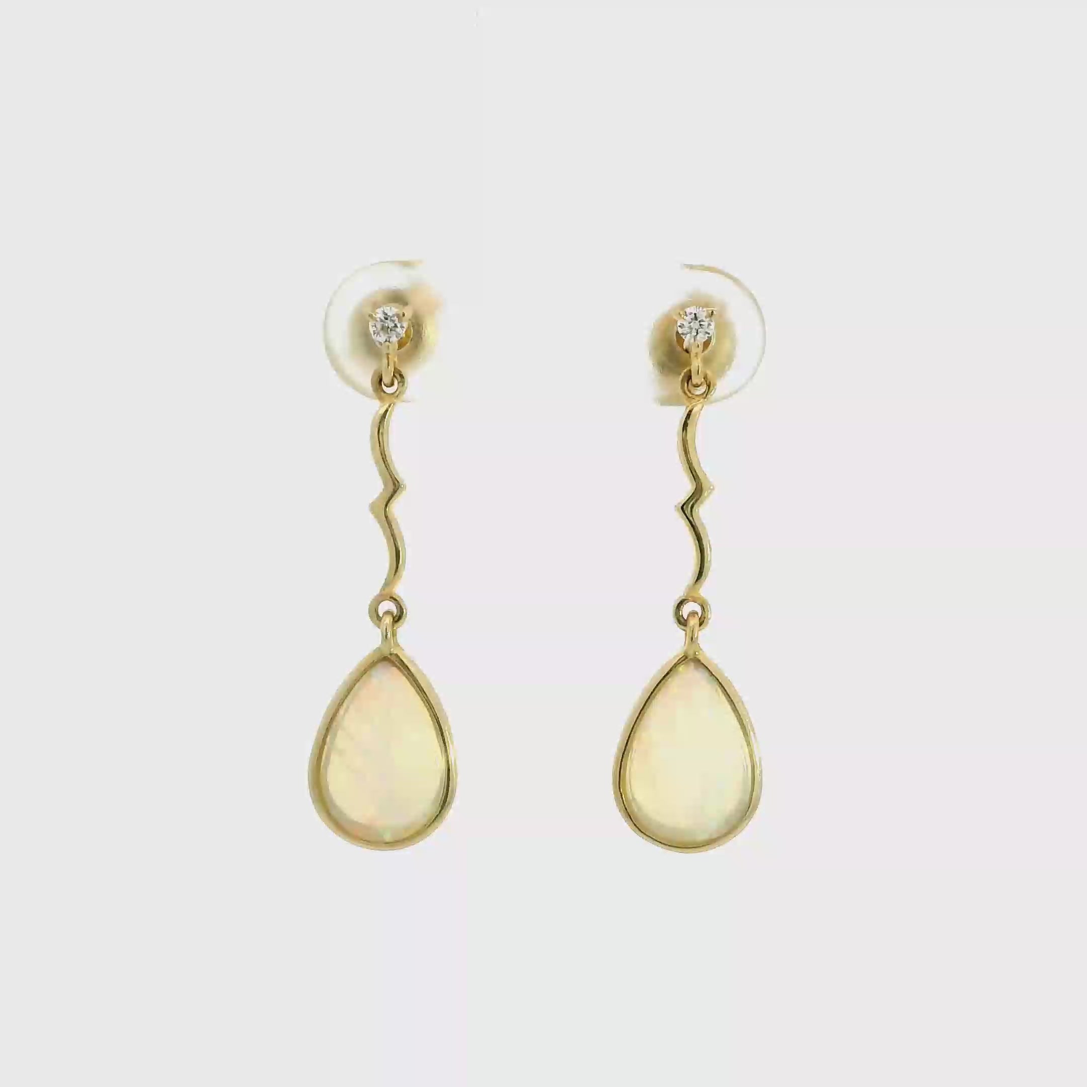 Video of Gold earrings with teardrop-shaped stones on a white background