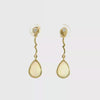 Video of Gold earrings with teardrop-shaped stones on a white background