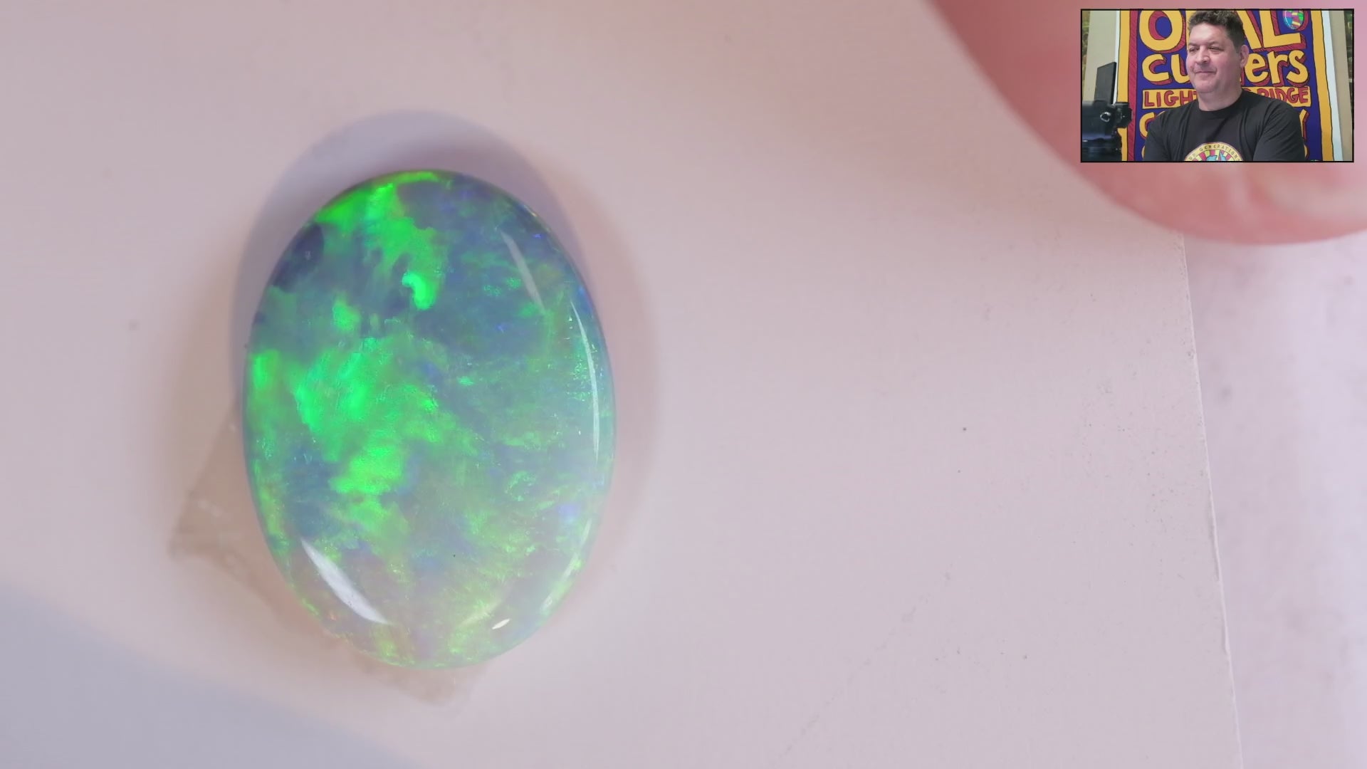 Video of an Oval-shaped opal gemstone with vibrant green and blue colours