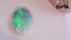Video of an Oval-shaped opal gemstone with vibrant green and blue colours