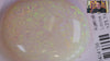 Video of an Opal stone with green specks on a white background