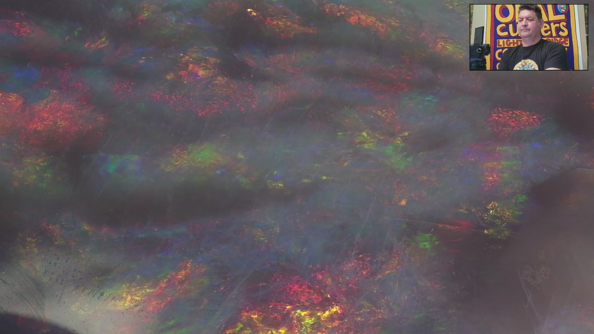 Video of an Opal stone with multicoloured fluorescence on a white background